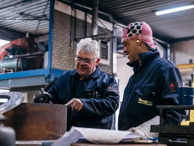 Lascoordinator en lasser bespreken werkstuk in Ferna werkplaats volgens ISO 3834 procedures